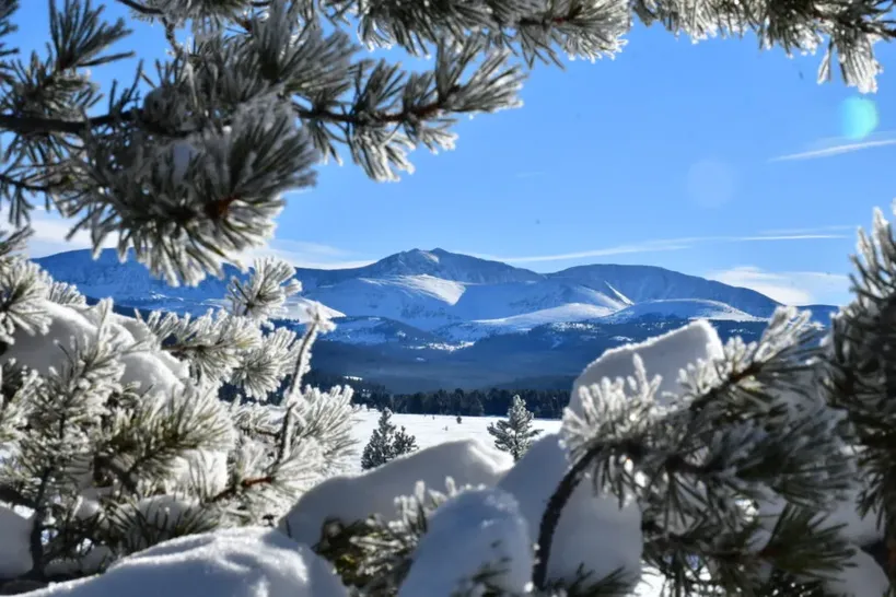 Wide open alpine meadow with fresh snow and distant mountains near Vail Colorado
