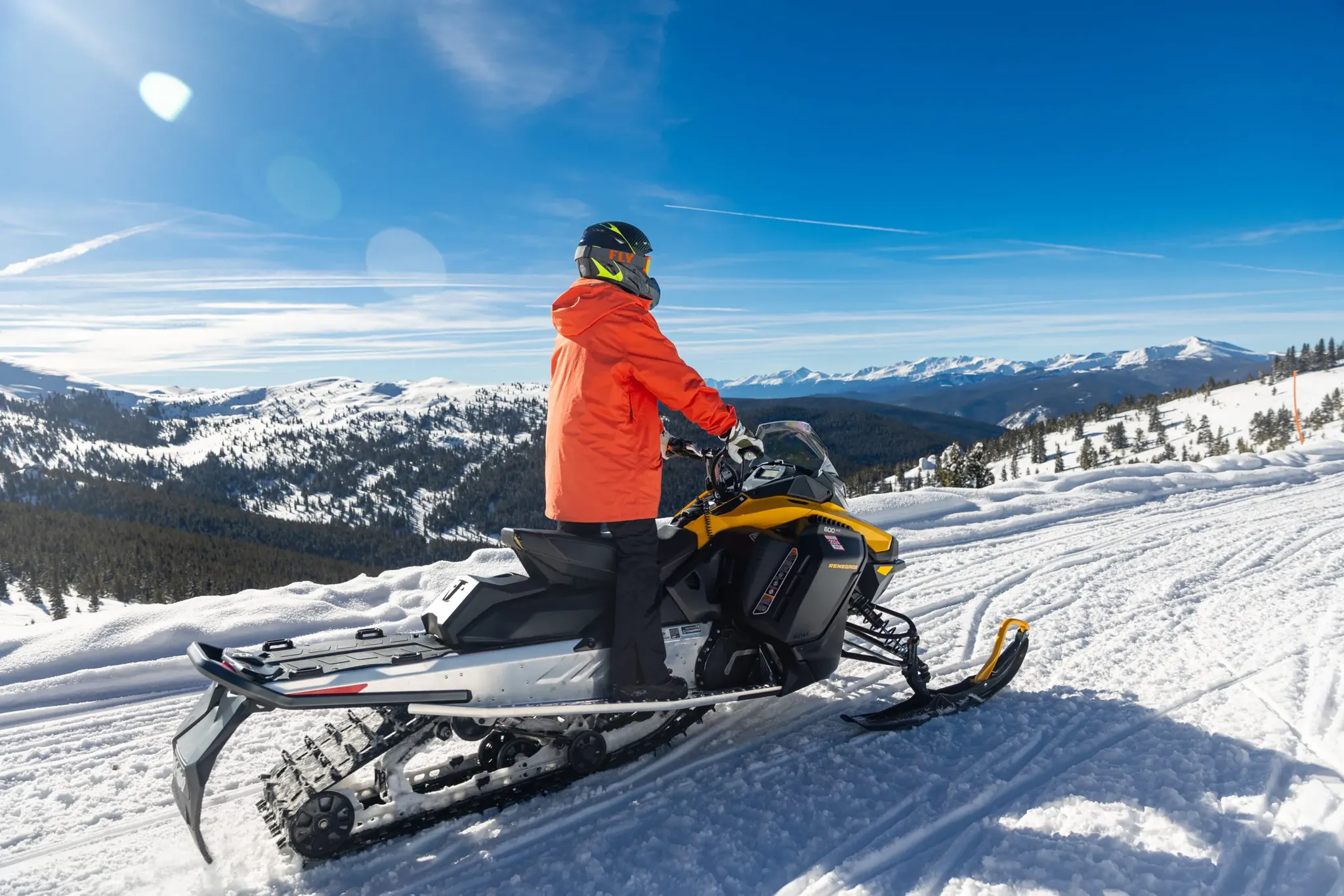 Snowmobile rider with panoramic mountain backdrop near Vail Colorado
